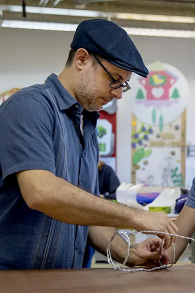 Markus Maciel, helps a student with a toy design project.