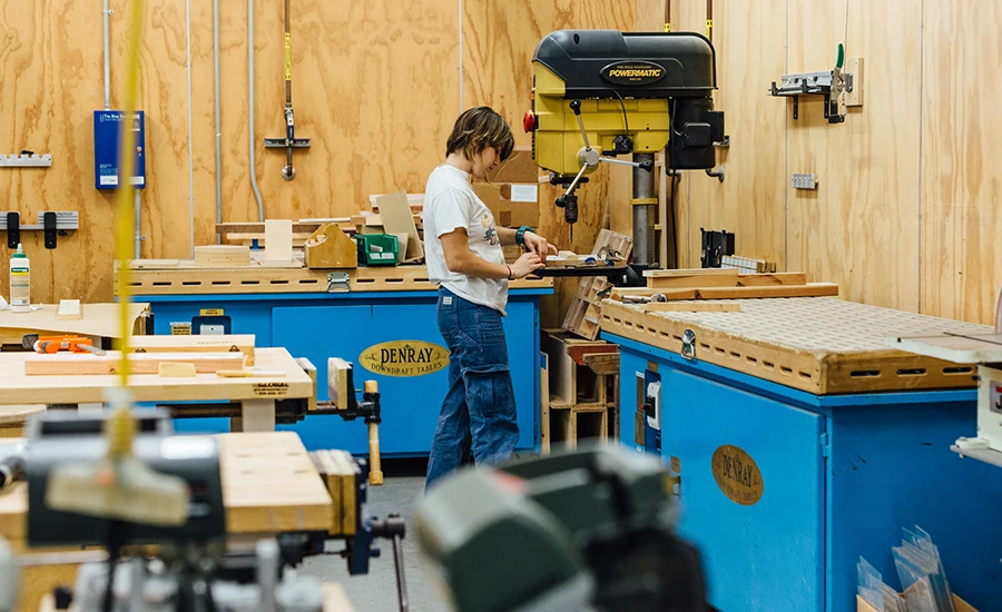 Student using machine in wood shop
