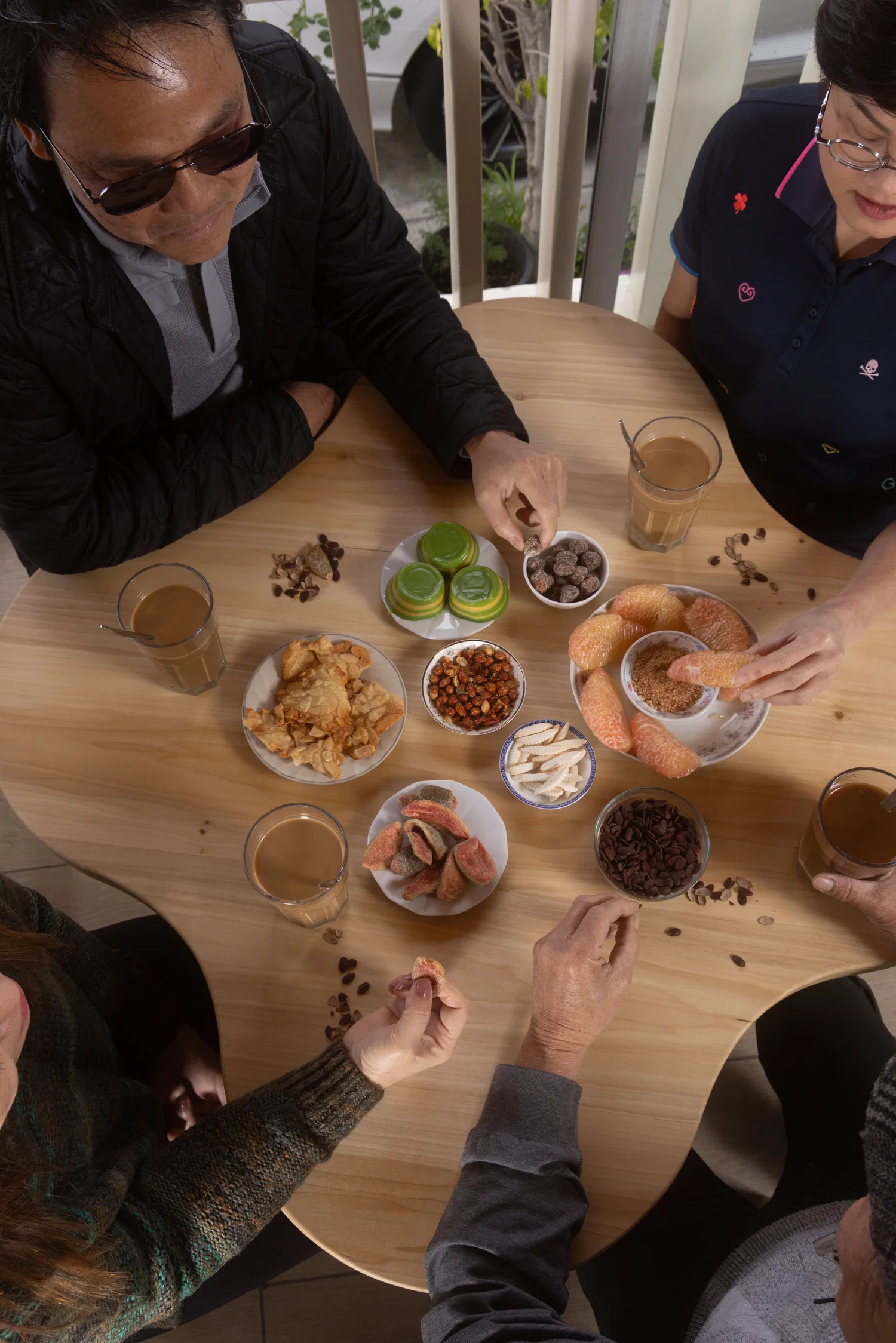Birds-eye view of a Vietnamese family enjoying brunch and coffee around the table.