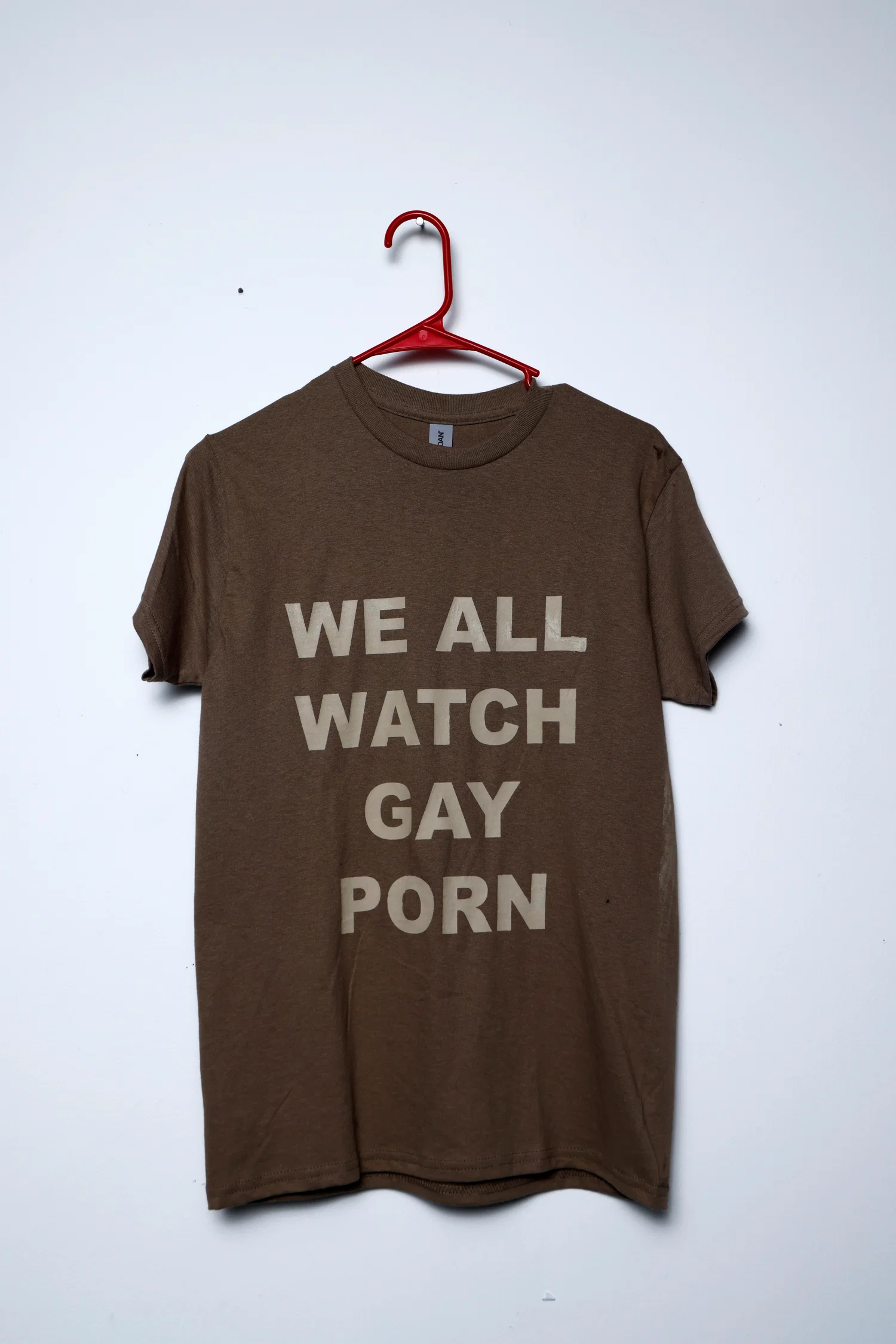 Brown screen printed tee shirt "WE ALL WATCH GAY PORN"