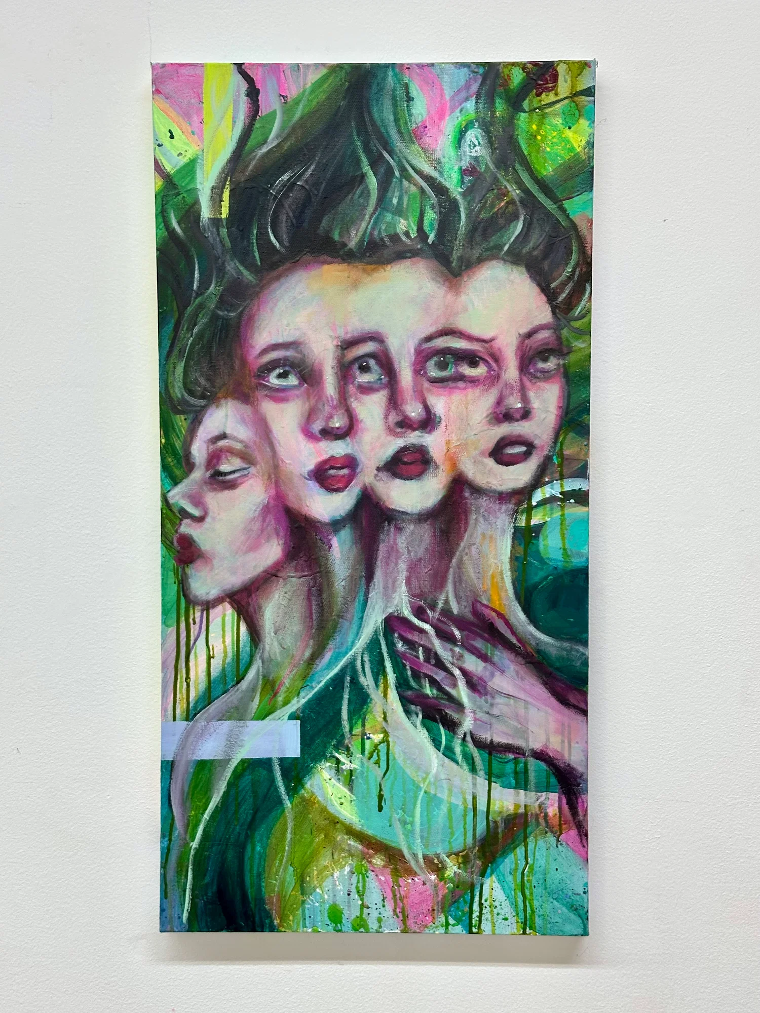 This acrylic painting depicting a portrait of four female faces blending together in front of a green, dripping background. Three of the faces are painted head on, whilst the face on the left is painted in profile.