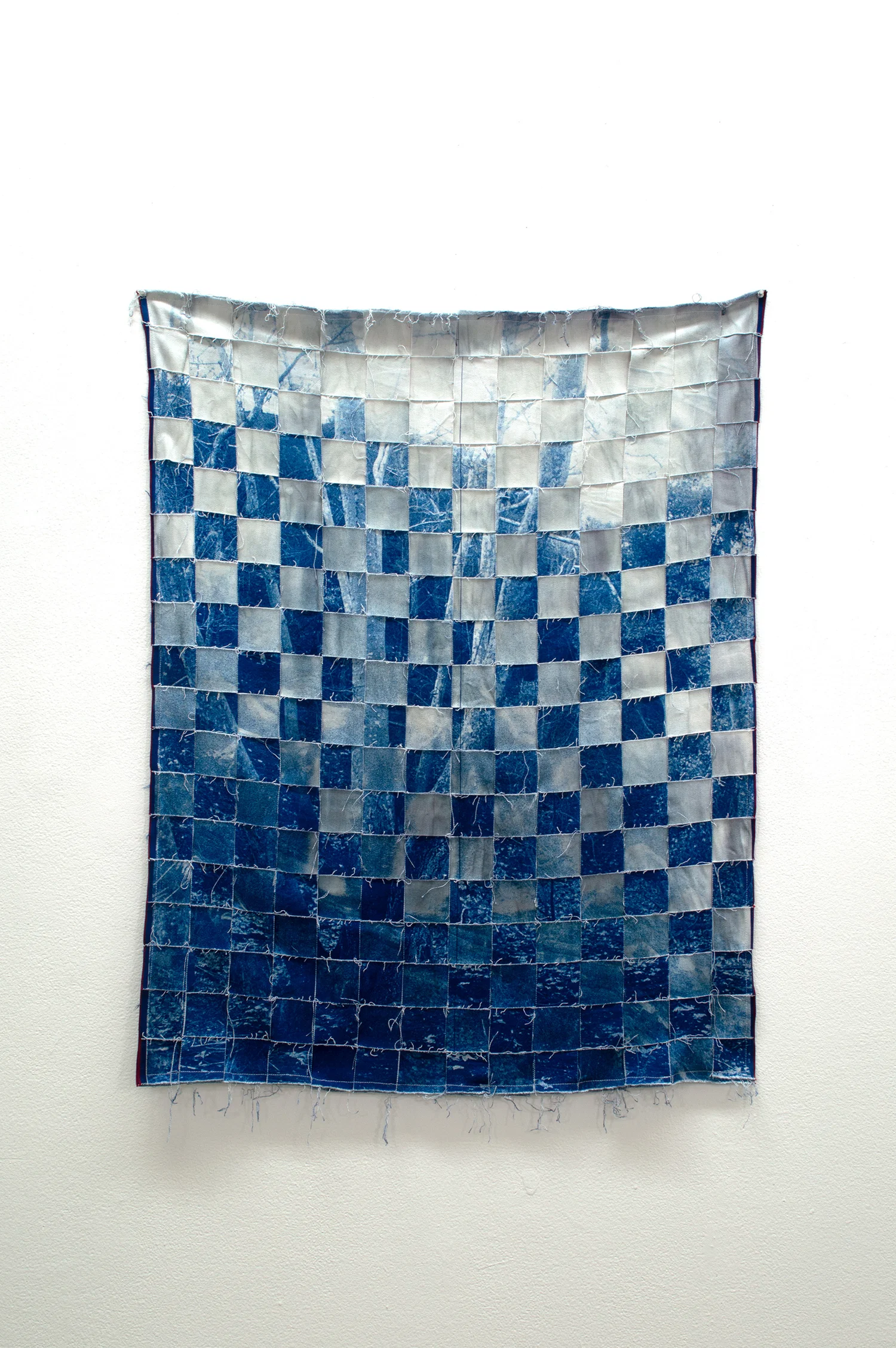 Two cyanotype photographs woven together into a tapestry-like print.