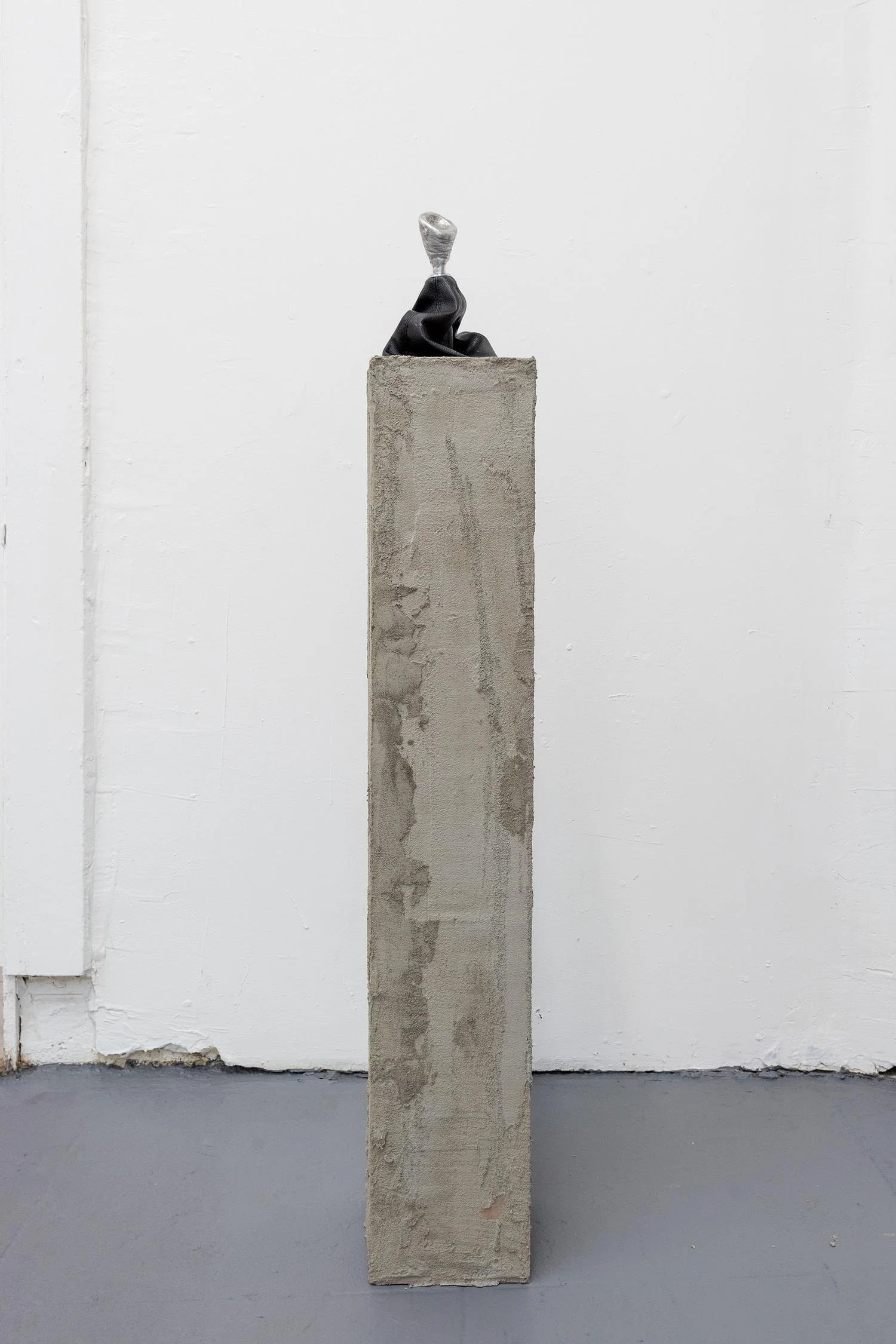 cement pedestal with stick shift on top. knob of shift is aluminum casted