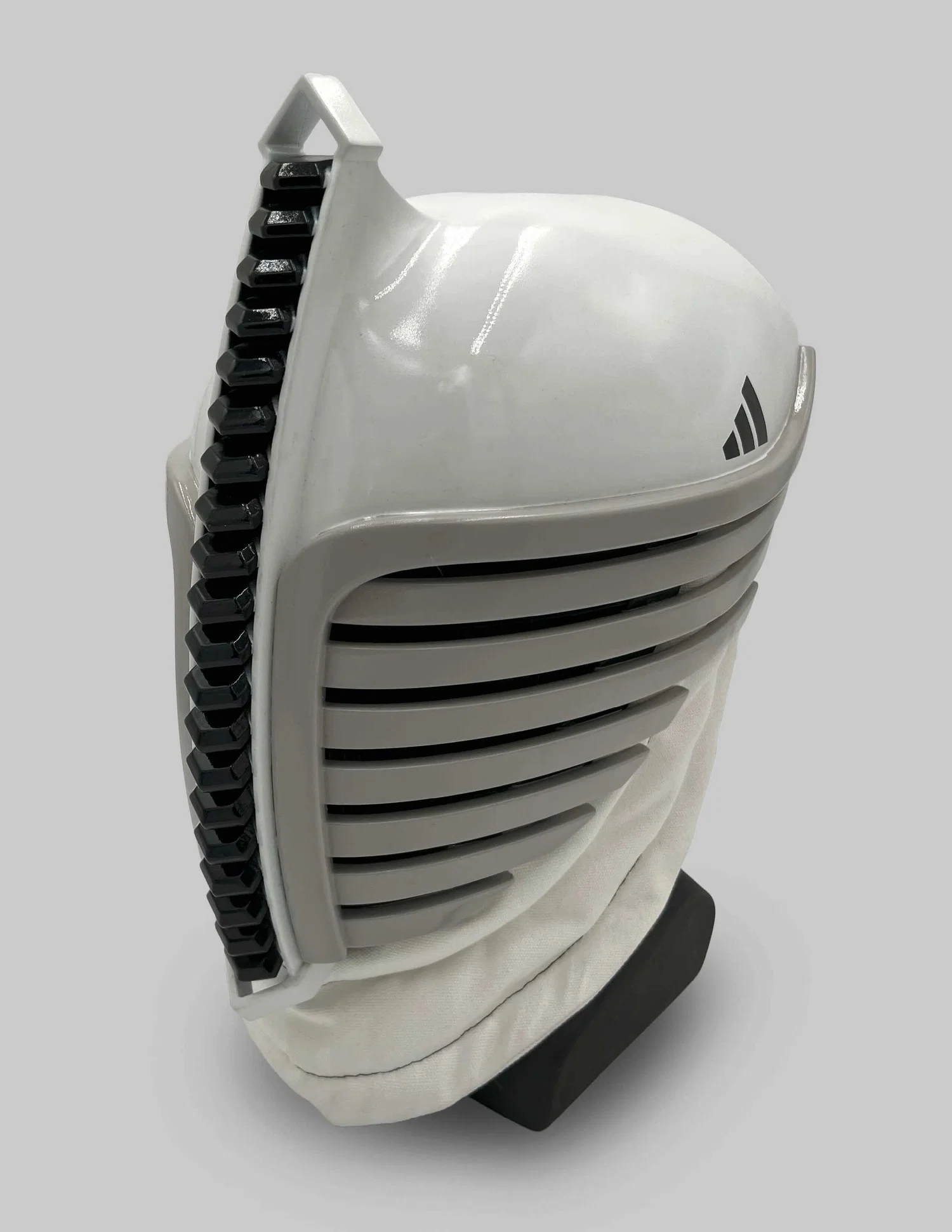 A fencing helmet that incorporates elements of the Adidas brand into its design. It has repetitive forms that run down the center of the mask, with stripes that curve out the face.