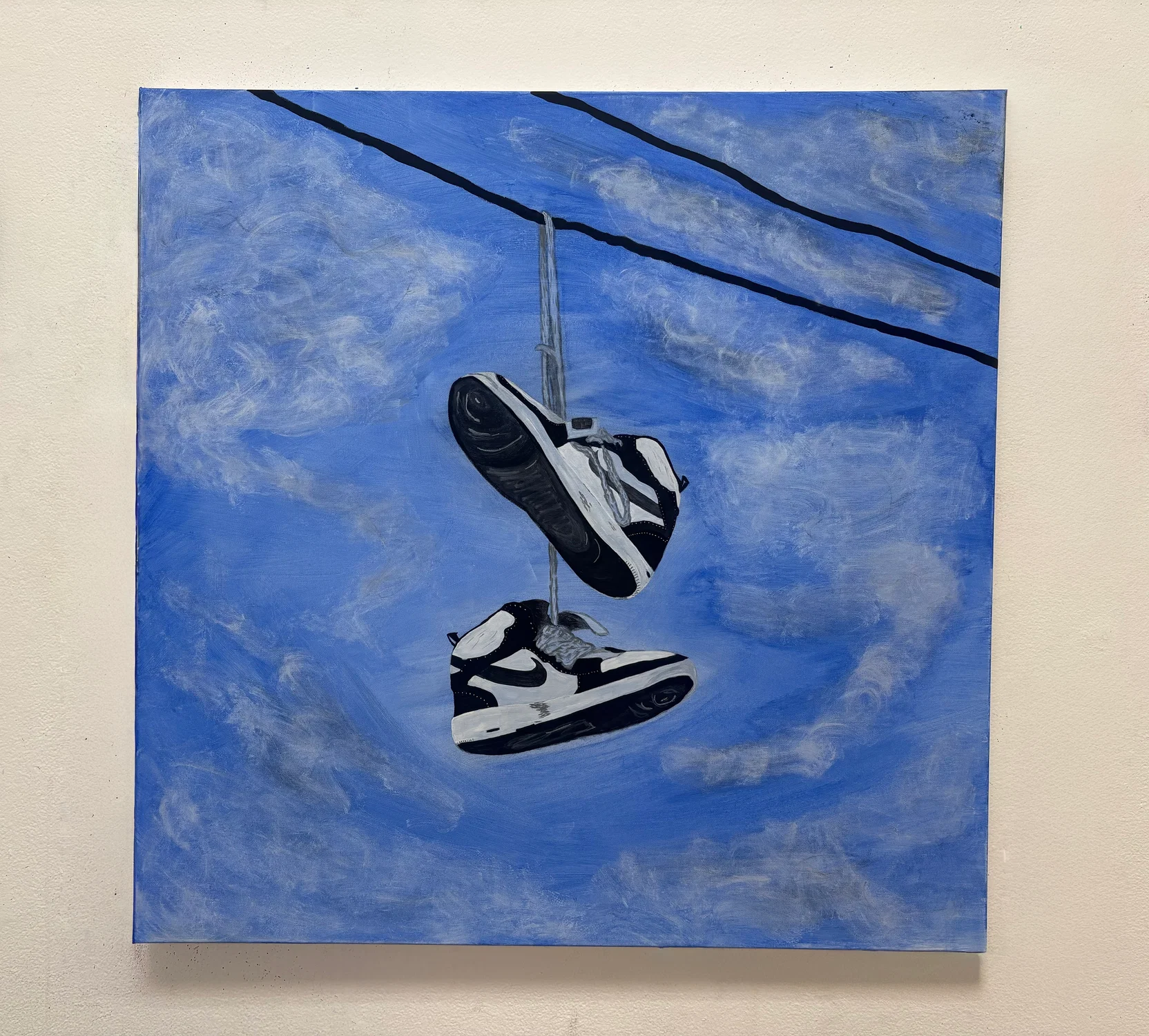 A painting that shows nike high-tops hung onto a street power line. Shoes hung onto a power line have many different reasons but for this case it is memorializing a deceased loved one, marking where they last stood.