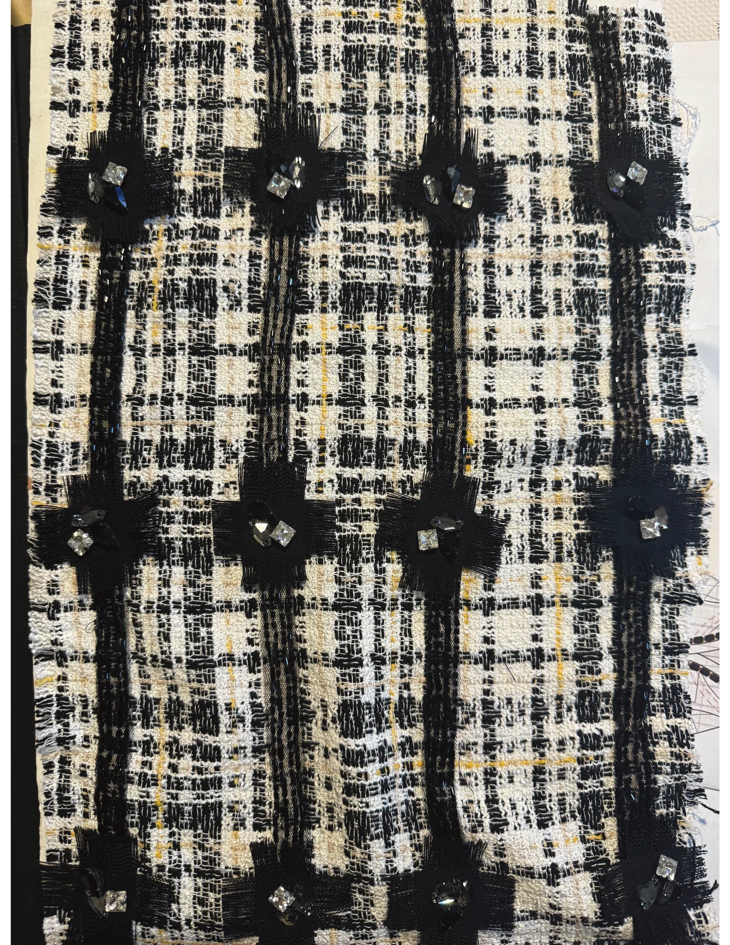 A black and white plaid tweed embellished with gems and beads.