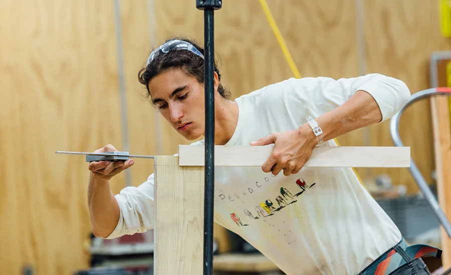 Image of student working on wooden furniture