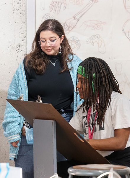 Teacher overseeing student working