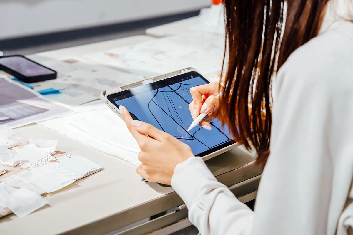 Student working on fashion work on an digital pad.