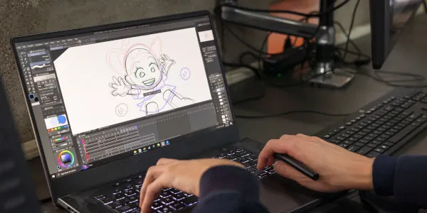 Student with only hands visible working on an animation sketch at a computer