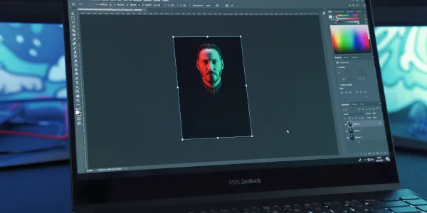 Laptop with Photoshop open and showing an image of a man's head and upper torso