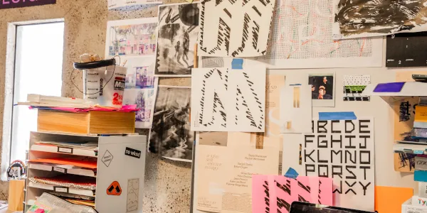 Many graphic design projects attaced to a wall