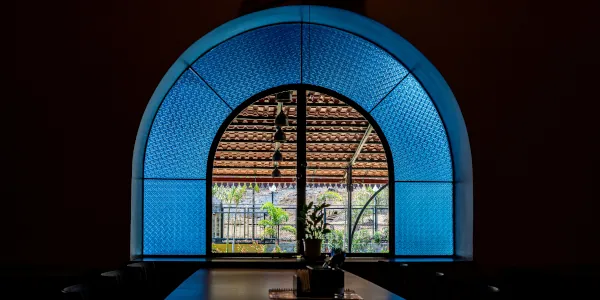 Restaurant table next to large arched window with large blue border