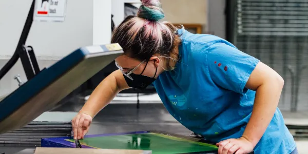 Female student prepares a screenprinting frame