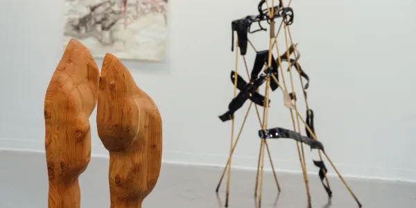 Two abstract sculputres, one wooden and the other made from rods and band of metal.