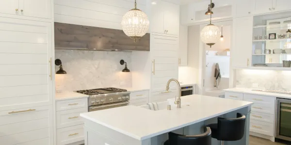 A mostly white kitchen with a center islamd