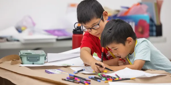 Two male Summer Youth camp students work together on a Myths and Legends project