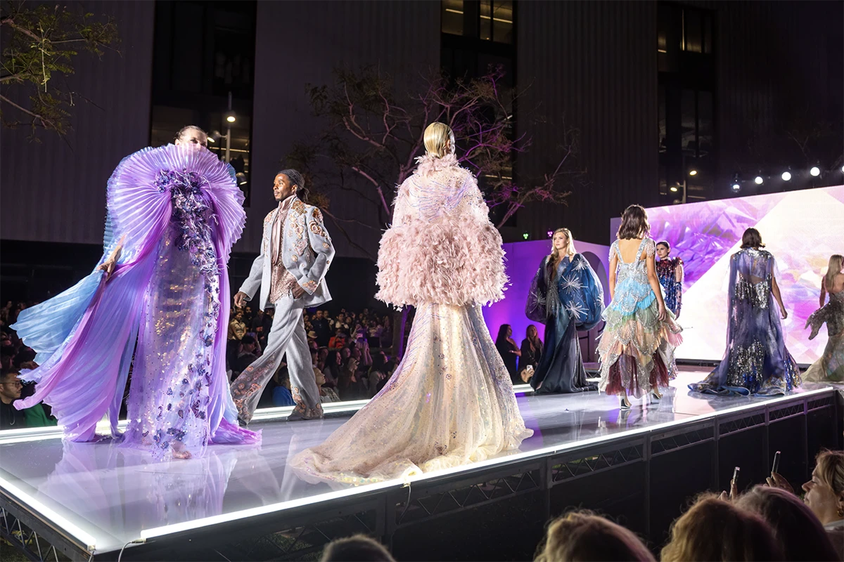 Models on a runway wearing colorful outfits designed by West Coast Exports