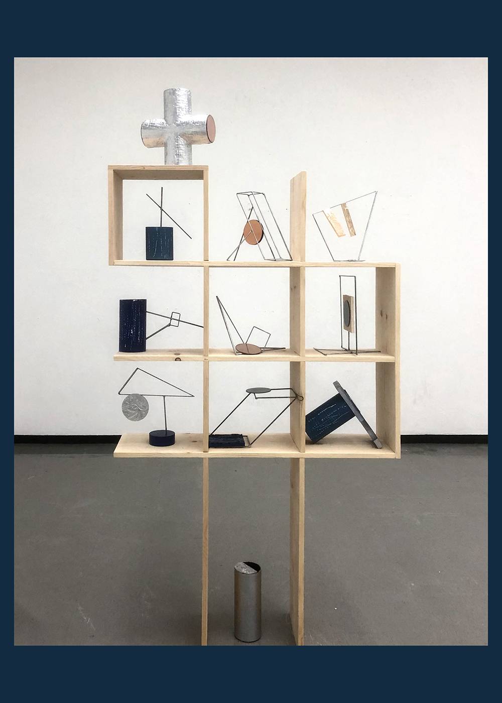 Mixed media sculpture resembling shelving unit and various objects displayed atop.