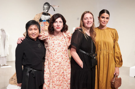 Four women standing with a fashion mannequin in the
    background