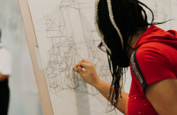 Student drawing at an easel