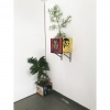Installation of two painted boxes with plants; one on the ground and the other mounted on the wall.