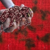 Red panel with collaged hands, holding expanding foam object.