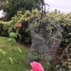 Welded figure sculpture installed on grass yard/garden.